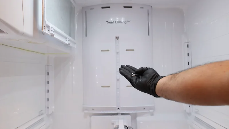 Technician checking the cooling vents inside a refrigerator during an in-home service call in Spartanburg SC